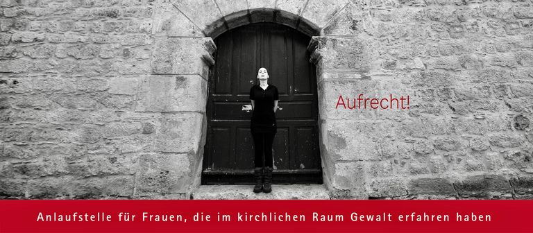 Frau vor Tür in kirchlichem Raum mit Aufruf „Aufrecht!“ gegen Gewalt.